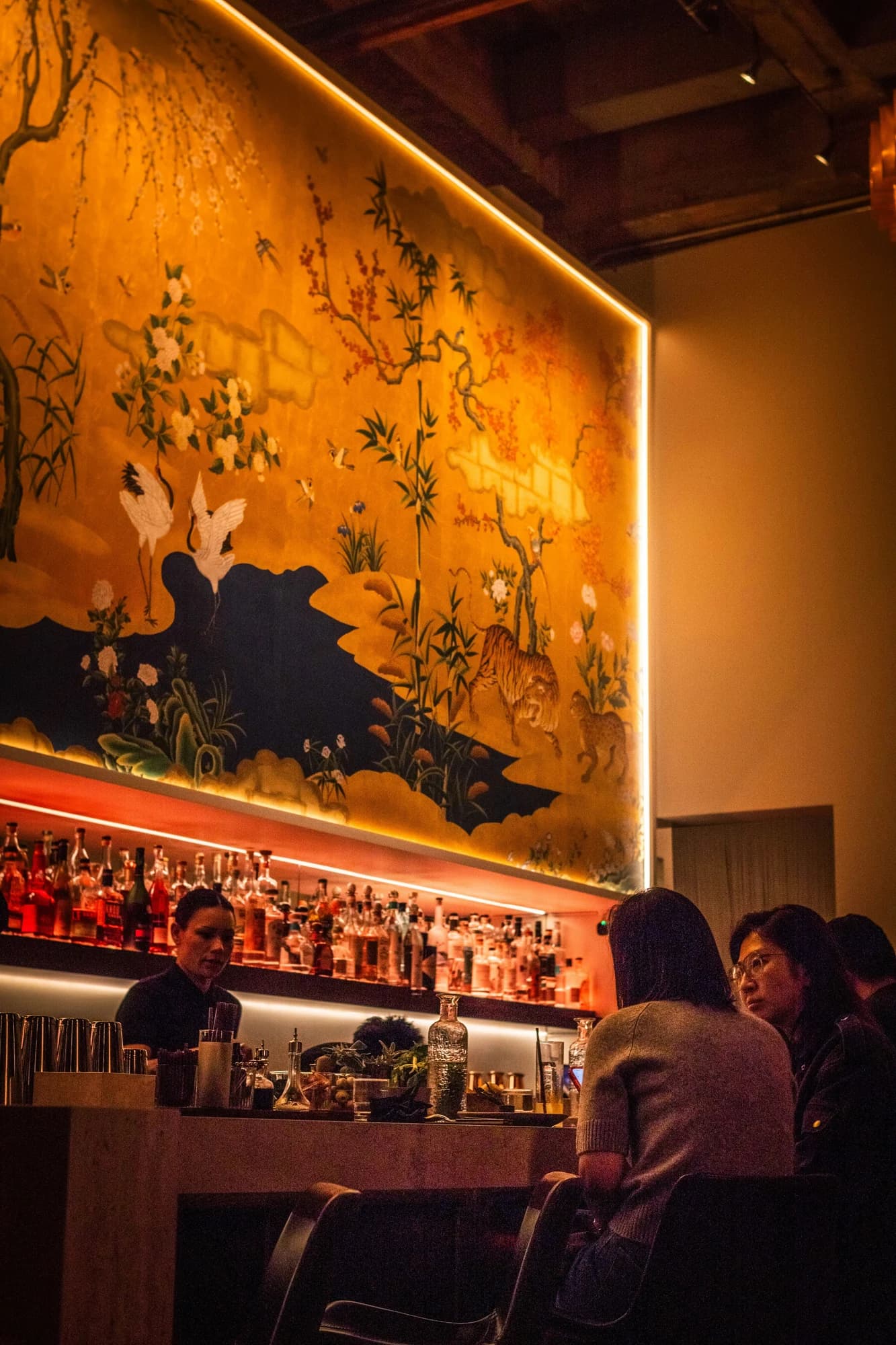 People at a bar with a large mural — representative photo, not taken at Blue Dog