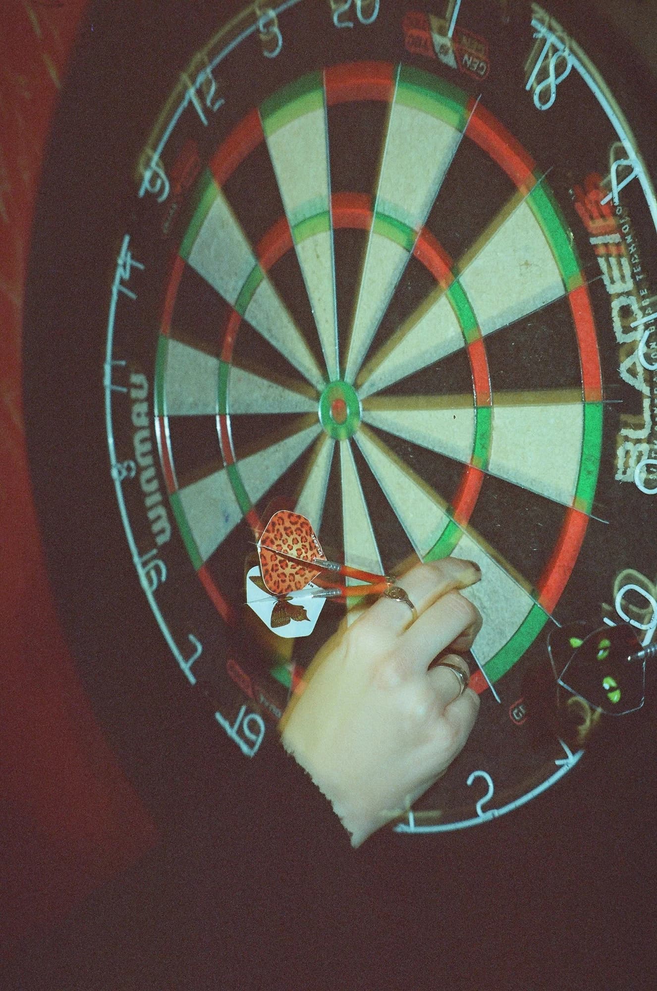 Hand throwing darts at a dartboard — representative photo, not taken at Boom Battle Bar — St. Enoch