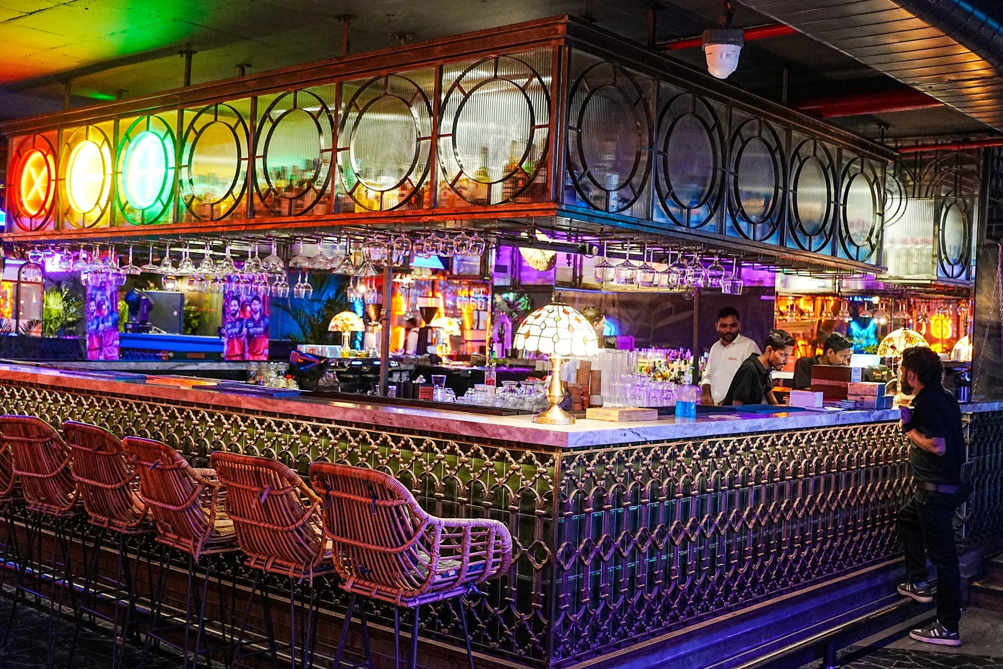 A vibrant bar interior with colorful lights and people. — representative photo, not taken at Delmonicas