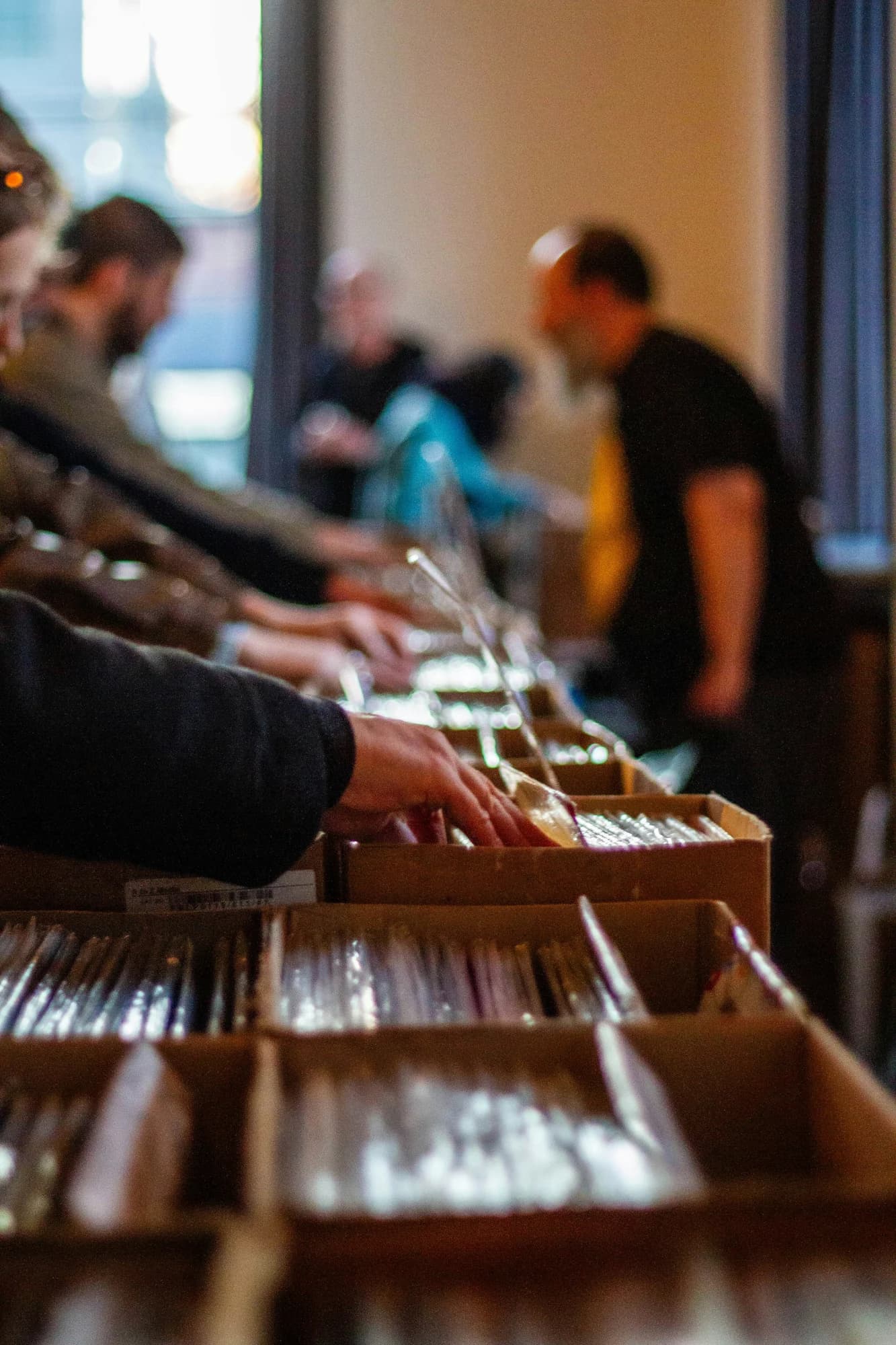 Hands search through vinyl records in cardboard boxes — representative photo, not taken at Monorail Music
