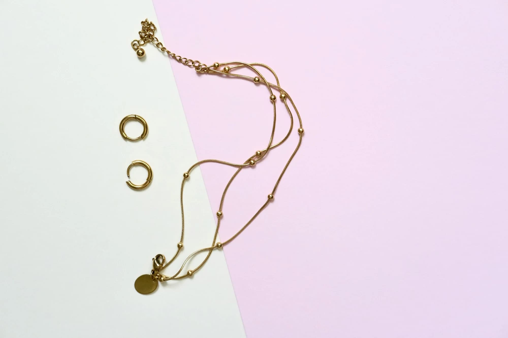 Gold necklace and earrings on pastel background. — representative photo, not taken at Moriconi — St. Enoch