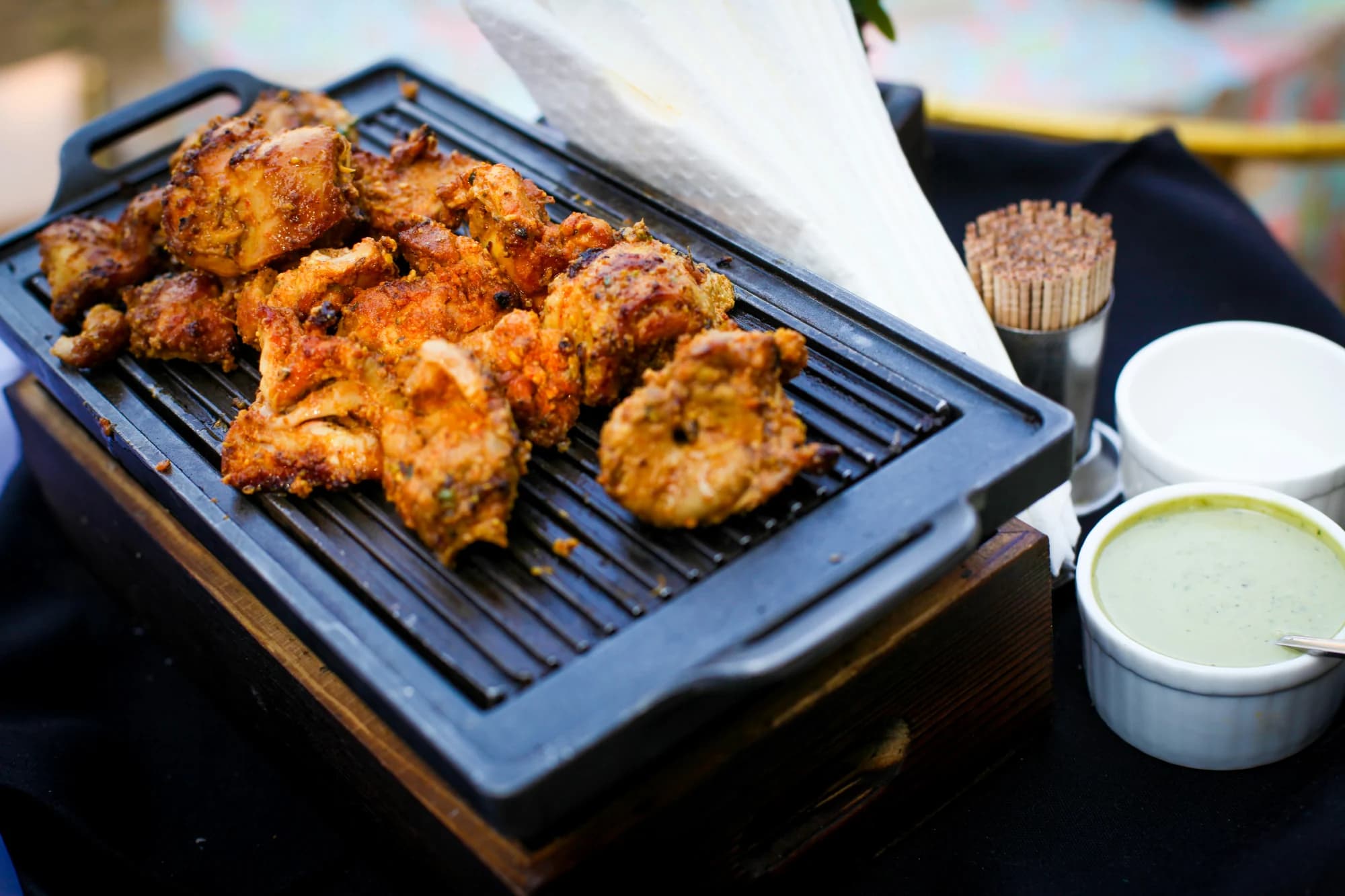 Tandoori chicken cooking on a grill — representative photo, not taken at Obsession of India