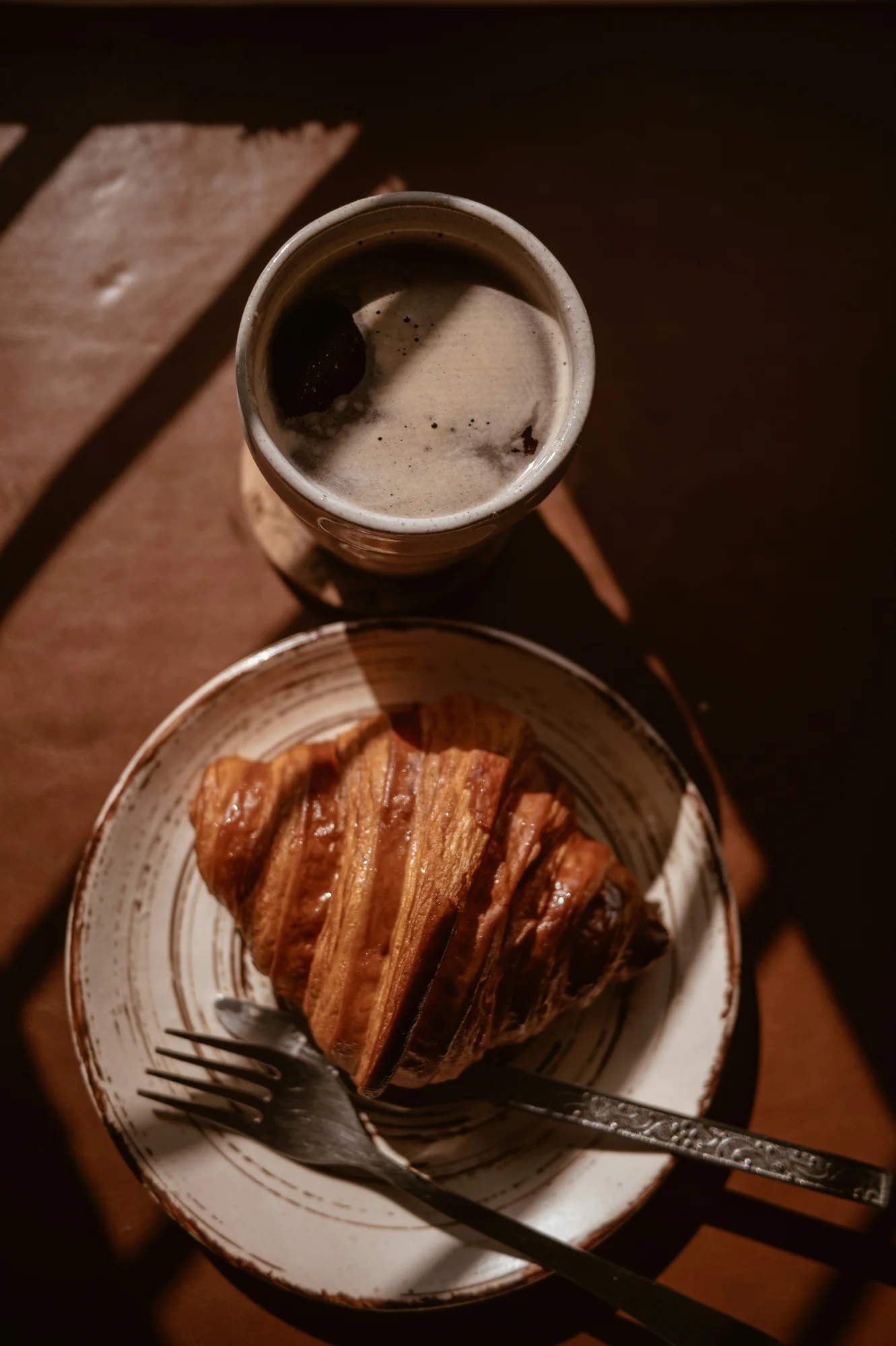 Coffee and a croissant on a rustic table — representative photo, not taken at Sarti — Wellington Street