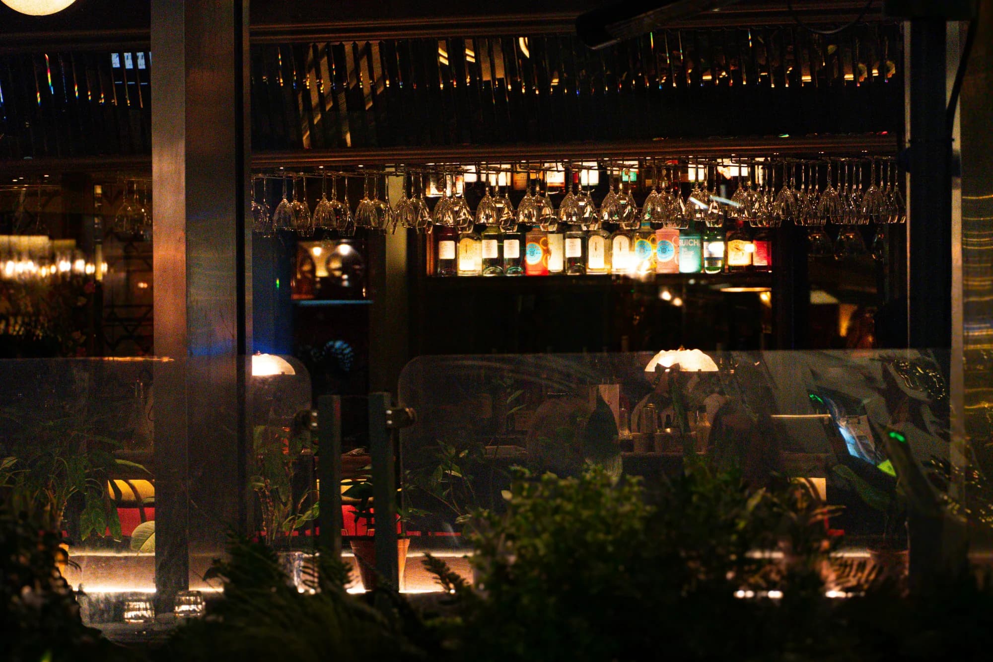 Bar interior with hanging wine glasses and lights — representative photo, not taken at The Drake