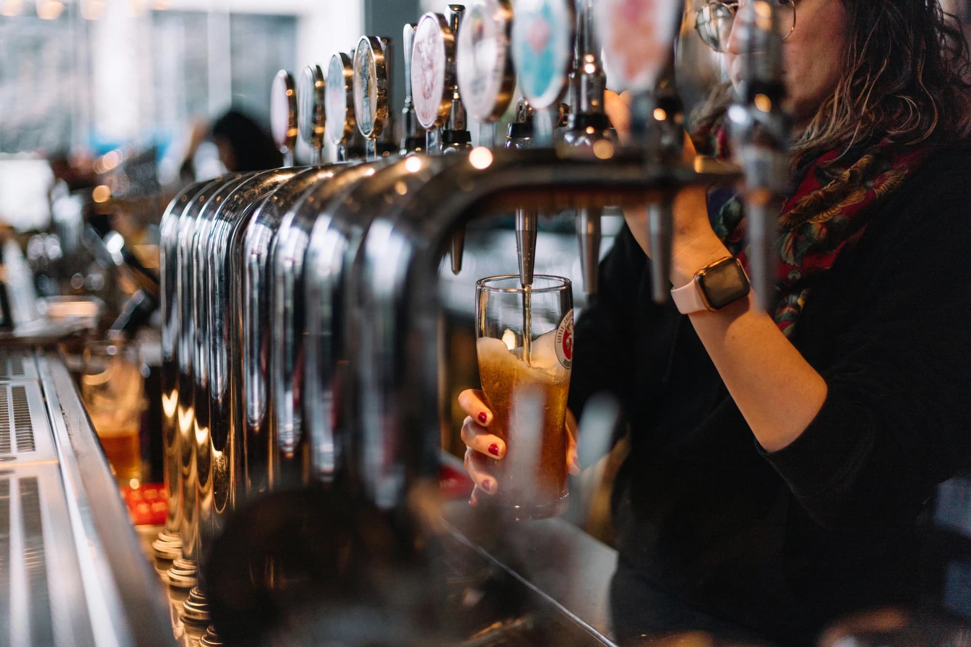A woman pouring a glass of beer at a bar — representative photo, not taken at The Tolbooth