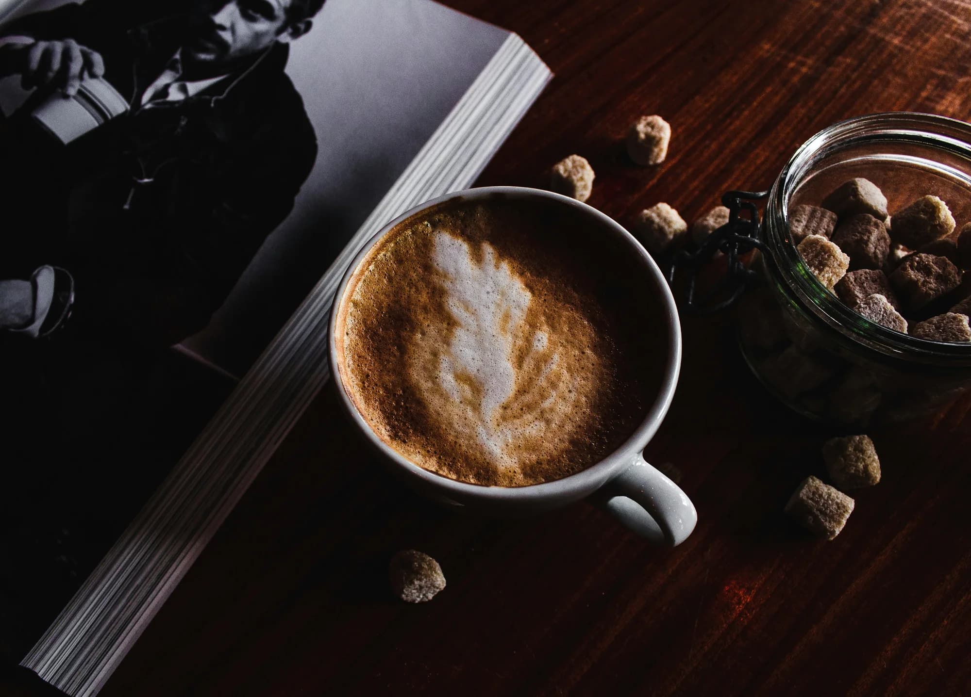 Coffee beside an open book — representative photo, not taken at Tibo