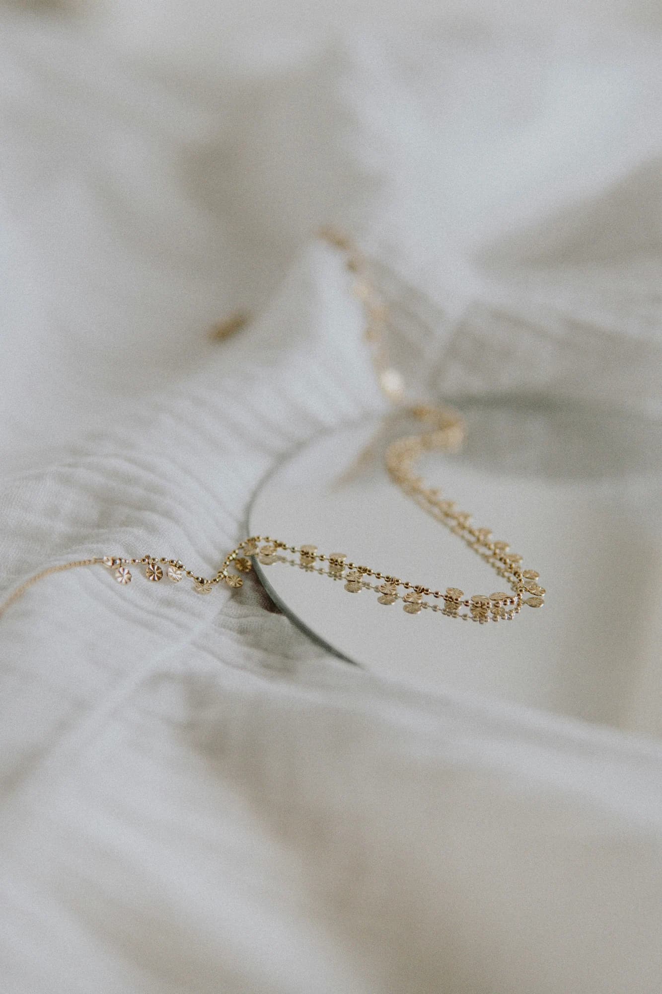 Gold necklace on white textile — representative photo, not taken at Warren James — St. Enoch