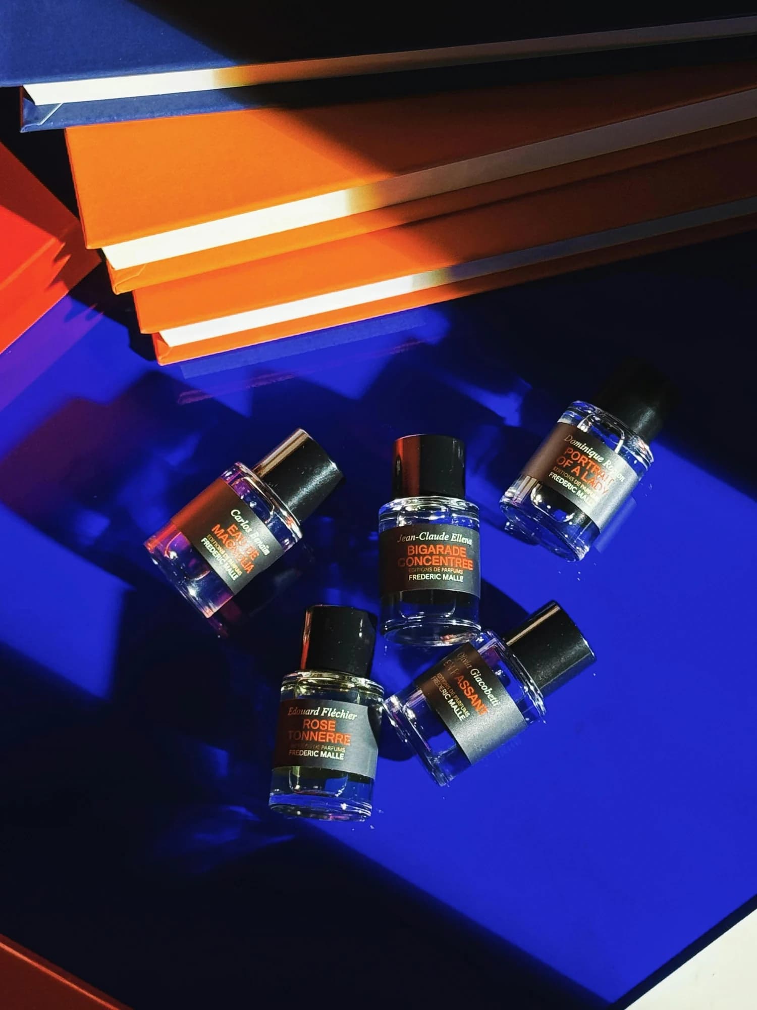 Five small perfume bottles arranged on a blue surface. — representative photo, not taken at Ya Dubai — St. Enoch